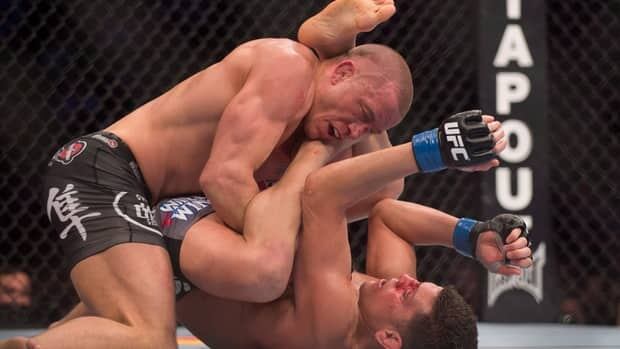 Georges St-Pierre, left, pins Nick Diaz to the canvas during their UFC 158 title fight Saturday in Montreal.