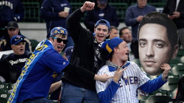 In this April 2013 file photo, Fans hold up a giant photo of Ryan Braun before the the Milwaukee Brewers take on the Colorado Rockies. Braun finally admitted to using perfromance-enhancing drugs Thursday after he was suspended last month.