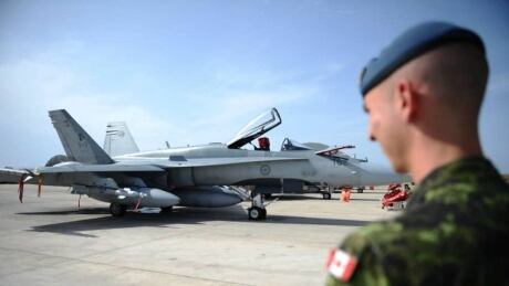 A Canadian soldier looks at a CF-18 as it sits loaded for flight at Camp Fortin on the Trapani-Birgi Air Force Base in Trapani, Italy, on Thursday, September 1, 2011. CF-18