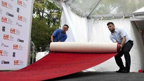 The red carpet is pulled into place at Roy Thomson Hall in Toronto on Wednesday, as final preparations are made for Thursday's opening gala at the Toronto International Film Festival. tiff-cp-9345791