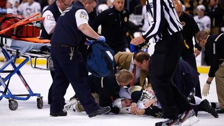Brooks Orpik #44 of the Pittsburgh Penguins is tended to by the medical staff on the ice in the first period after an altercation with Shawn Thornton #22 of the Boston Bruins in the first period during the game at TD Garden on December 7, 2013 in Boston, Massachusetts. Orpik, stretcher