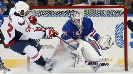 Henrik Lundqvist #30 of the New York Rangers kicks aside a shot by Joel Ward #42 of the Washington Capitals during the third period at Madison Square Garden on December 8, 2013 in New York City. The Capitals defeated the Rangers 4-1. Henrik Lundqvist, Joel Ward
