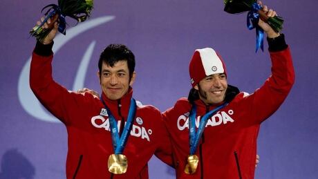 Brian McKeever of Canada, right, and his brother and guide Robin McKeever celebrate their gold medal win in the men's 10 km Classic cross country visually impaired race during the 2010 Winter Paralympic Games in Whistler, Thursday, March 18, 2010. Brian McKeever