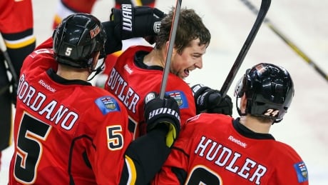 Calgary Flames defenceman Chris Butler (44) celebrates his game-winning goal against the Carolina Hurricanes with Calgary Flames defenceman Mark Giordano (5) and left wing Jiri Hudler (24) in overtime Thursday. Chris Butler