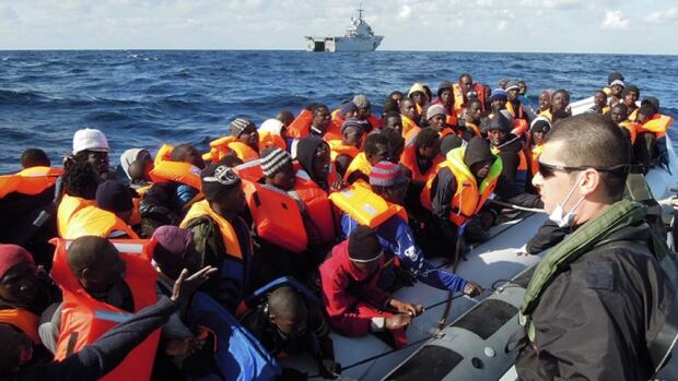 A member of the Italian navy looks on during an operation to rescue rafts crowded with migrants in the Mediterranean Sea south of Sicily on Wednesday.