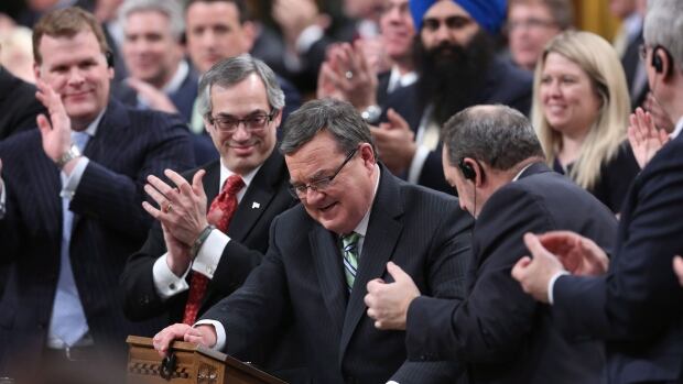 Minister of Finance Jim Flaherty is applauded by his caucus as he arrives to table the budget in the House of Commons.