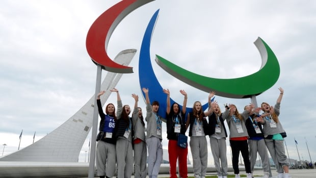 Spectators pose for a photograph on Thursday next to a sculpture of the official symbol of the 11th Paralympic Games, which begin Friday in Sochi, Russia.