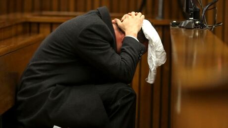 Oscar Pistorius covers his head with a handkerchief after he had reached for a bucket at his feet while listening to cross questioning about the events surrounding the shooting death of his girlfriend Reeva Steenkamp, in his second week in court during his trial in Pretoria, South Africa, Monday, March 10, 2014. Pistorius is charged with the shooting death of his girlfriend Steenkamp, on Valentines Day in 2013. (AP Photo/Siphiwe Sibeko, Pool) South Africa Pistorius Trial
