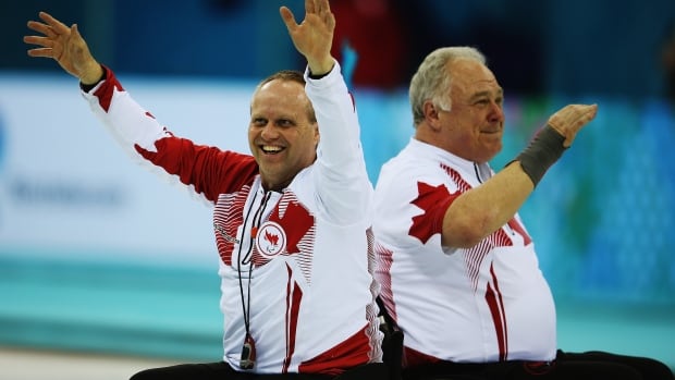 Team Canada's Dennis Thiessen, left, celebrates with Jim Armstrong after beating Russia to win gold in wheelchair curling at the Sochi Paralympics on Saturday. It is Canada's third straight gold in the event.