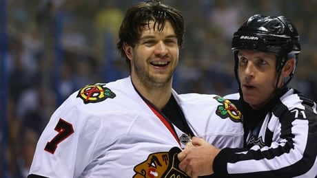 Referee Brad Kovachick restrains Brent Seabrook of the Chicago Blackhawks after his hit knocked David Backes of the St. Louis Blues, not pictured, out of Game 2 on Saturday in St. Louis, Missouri. david backes brent seabrook game 2