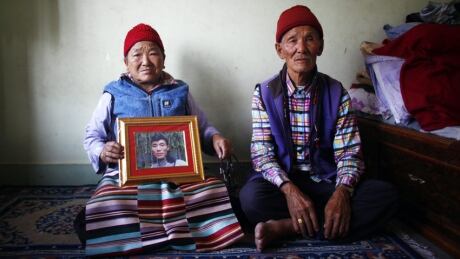 Nimdige Sherpa holds a portrait of her son Ang Kaji Sherpa, killed in an avalanche on Mount Everest, with her husband Ankchu Sherpa seated beside her in their rented apartment in Katmandu, Nepal, Wednesday, April 23, 2014. Dozens of Sherpa guides packed up their tents and left Mount Everest's base camp Wednesday, after the avalanche deaths of 16 of their colleagues exposed an undercurrent of resentment by Sherpas over their pay, treatment and benefits. (AP Photo/Niranjan Shrestha) Mount Everest Sherpas