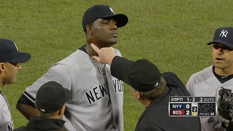 In this April 23, 2014 photo taken from video and provided by ESPN, home plate umpire Gerry Davis touches the neck of New York Yankees starting pitcher Michael Pineda in the second inning of the Yankees' baseball game against the Boston Red Sox at Fenway Park in Boston. Pineda was ejected after umpires found a foreign substance on his neck. (AP Photo/ESPN) pineda-tar-140423-620