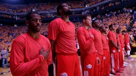 Los Angeles Clippers players listen to the national anthem wearing their warmup jerseys inside out to protest alleged racial remarks by team owner Donald Sterling before Game 4 of an opening-round NBA basketball playoff series against the Golden State Warriors on Sunday, April 27, 2014, in Oakland, Calif. (AP Photo/Marcio Jose Sanchez) Clippers Warriors Sterling Players Basketball