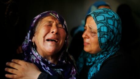 Palestinian relatives mourn during the funeral of members of Hamad family in the town of Beit Hanoun in the northern Gaza Strip July 9, 2014. Militants in Gaza fired more rockets at Tel Aviv on Wednesday, targeting Israel's heartland after Israeli attacks in the enclave that Palestinian officials said have killed at least 27 people. Israel assassinated a senior local leader of the Islamic Jihad militant group in the northern Gaza Strip early on Wednesday, neighbours and hospital officials said, and five others including family members were killed. An Israeli military spokeswoman said she had no initial details on the strike.The militant, Hafez Hamad, two brothers and his parents were killed when his house was bombed in an air strike in the town of Beit Hanoun in the northern Gaza Strip, Hamas media and Gaza interior ministry said. An unidentified woman in the house was also killed. PALESTINIANS-ISRAEL/