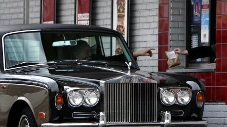An unidentified motorist behind the wheel of a Rolls Royce picks up a meal at a Burger King, fast food restaurant drive-thru, in northeast Philadelphia on Monday Dec. 15, 2008. APTOPIX Rolls Royce Drive Thru