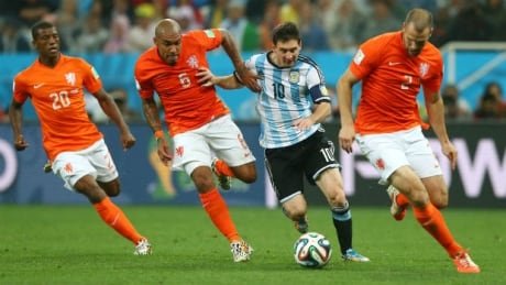 Argentina's Lionel Messi is chased down by three Dutch players during the teams' semifinal clash at the 2014 FIFA World Cup in Brazil. Argentina, Netherlands, World Cup