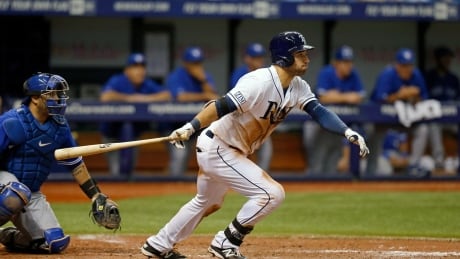 The Rays' Kevin Kiermaier follows through on an RBI single in front of Blue Jays catcher Dioner Navarro in the seventh inning on Saturday. Kiermaier drove in three runs in a 10-3 Tampa Bay victory. kiermaier-kevin