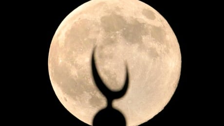 A perigee moon, also known as a 'supermoon,' rises over a crescent of a minaret of grand Faisal mosque in Islamabad, Pakistan, Saturday. Pakistan Supermoon
