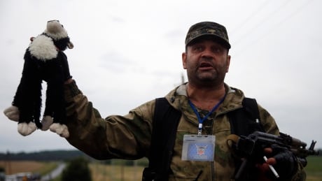 A pro-Russian separatist holds up a stuffed toy found at the crash site of Malaysia Airlines flight MH17, near the settlement of Grabovo in the Donetsk region, July 18, 2014. As international investigators head to rebel-held eastern Ukraine to piece together what - and who - caused the Malaysian airliner to plunge into the steppe, securing evidence in the middle of a war zone is a major challenge. REUTERS/Maxim Zmeyev (UKRAINE - Tags: DISASTER POLITICS TRANSPORT CONFLICT CIVIL UNREST TPX IMAGES OF THE DAY) - RTR3Z9NG Malaysia Airlines Ukraine plane crash separatist plush doll