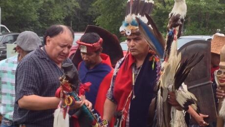 Saskatoon elder Paul Laliberte giving the bear staff to marcher Guyustis Kigame. bear staff