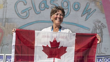 Trap shooter Susan Nattrass smiles as she displays the Canadian flag as members of the Canadian team attend their welcome ceremony at the Commonwealth Games in Glasgow, Scotland on Monday, July 21, 2014. Nattrass says she will soak up every moment of the opening ceremonies. nattrass-140721-620