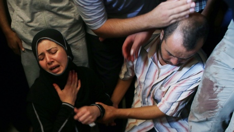 Palestinian daughter of Tawfiq al-Aga, who medics said was killed in Israeli shelling, mourns next to her father body during his funeral in Khan Younis in the southern Gaza Strip July 23, 2014. Israeli forces pounded Gaza on Wednesday, meeting stiff resistance from Hamas Islamists and sending thousands of residents fleeing, as U.S. Secretary of State John Kerry said on a visit to Israel ceasefire talks had made some progress. Israel launched its offensive on July 8 to halt missile salvoes by Hamas and its allies, struggling under the weight of an Israeli-Egyptian economic blockade and angered by a crackdown on their supporters in the nearby occupied West Bank. PALESTINIANS-ISRAEL/