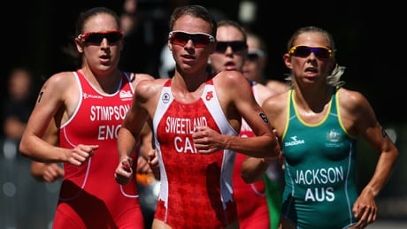 GLASGOW, SCOTLAND - JULY 24: Kirsten Sweetland of Canada leads Jodie Stimpson of England as they compete in the Women's Triathlon at Strathclyde Country Park during day one of the Glasgow 2014 Commonwealth Games on July 24, 2014 in Glasgow, United Kingdom. sweetland-kirsten-140724-620