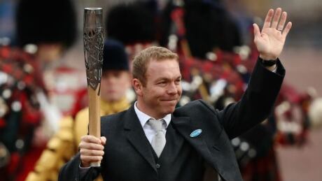 Sir Chris Hoy carries the Queen's Baton at Buckingham Palace on October 9, 2013. Sir Chris Hoy