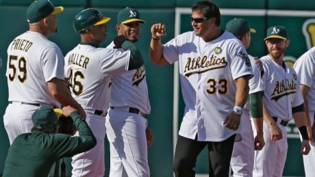 Former Oakland Athletic Jose Canseco (33) is welcomed by the team, including first base coach Tye Waller (46) during a pre-game ceremony on Saturday honouring the reunion of players from the 1989 world championship team. Orioles Athletics Baseball