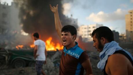 A Palestinian reacts following what witnesses said was an Israeli air strike on a building in Gaza City July 24, 2014. Gazan authorities said Israeli forces shelled a shelter at a U.N.-run school on Thursday, killing at least 15 people as the Palestinian death toll in the conflict climbed over 750 and attempts at a truce remained elusive. The Israeli military said its troops were fighting gunmen from Hamas, which runs Gaza, in the area and that it was investigating the incident. Hamas fired rockets at Tel Aviv and said its gunmen carried out a lethal ambush on Israeli soldiers in north Gaza. REUTERS/Mohammed Salem (GAZA - Tags: POLITICS CIVIL UNREST CONFLICT MILITARY) - RTR400UW MIDEAST-GAZA/