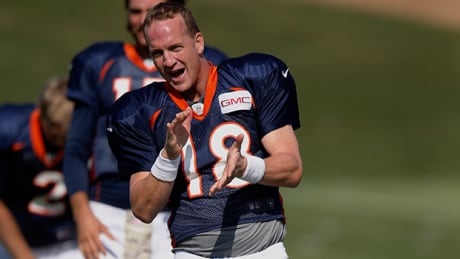 Denver Broncos star quarterback Peyton Manning (18) jukes to 'Rocky Top' at training camp in Englewood, Colo., on Monday. manning-peyton-140728