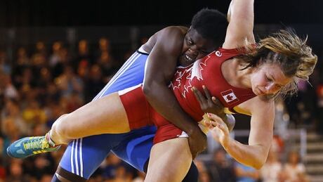 Canadian wrestler Erica Wiebe, right, defeated Nigeria's Blessing Onyebuchi in the semifinals, then went on to win gold in the women's 75-kg division. wiebe-erica-140729-620