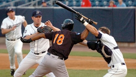 John Nathans, right, tries to prevent Jose Offerman (18) from hitting pitcher Matt Beech in Bridgeport, Conn., on Aug. 14, 2007. Offerman Bat Attack Baseball