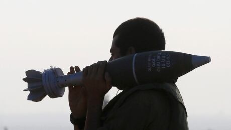 An Israeli soldier carries a 120 mm mortar shell outside the central Gaza Strip July 31, 2014. Israeli Prime Minister Benjamin Netanyahu, facing international alarm over a rising civilian death toll in Gaza, said Thursday he would not accept any ceasefire that stopped Israel completing the destruction of militant infiltration tunnels. MIDEAST-GAZA-Israeli-soldier