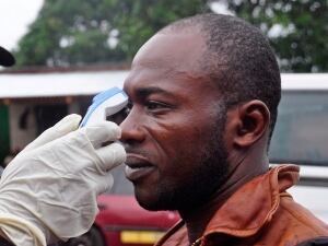 A man's temperature is measured before he is allowed into a business centre, as fear of the Ebola virus spreads through the city of Monrovia, Liberia on Aug. 9. Guinea announced the closure of its borders with Sierra Leone and Liberia on Saturday in a bid to halt the spread of the virus that has killed nearly 1,000 people in the three African countries this year.