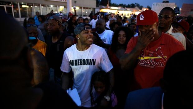 St. Louis native Nelly, centre, walks the streets with protesters Monday in Ferguson.