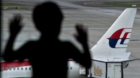 A young boy looks at a Malaysia Airlines plane parked on the tarmac at Kuala Lumpur International Airport in Sepang on August 29, 2014. Malaysia Airlines will slash 6,000 jobs, trim its route network, and replace its CEO under plans announced to stave off bankruptcy after two air tragedies plunged the already troubled carrier deeper into crisis.State investment fund Khazanah Nasional, which controls the failing flag carrier, said it would pump 6 billion ringgit ($1.9 billion) into the airline, hoping the changes will return the company to profitability within three years. AFP PHOTO / MANAN VATSYAYANA (Photo credit should read MANAN VATSYAYANA/AFP/Getty Images) Malaysia Airlines bucket list promotion