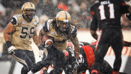 Winnipeg Blue Bombers Paris Cotton, centre, dodges Calgary Stampeders players during first half CFL football action in Calgary, Saturday, Nov. 1, 2014. Winnipeg vs. Calgary