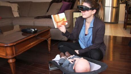 Beitz, who was diagnosed with Stargardt Disease as a child, uses the eSight device to read to her son, six-week-old Aksel. Kathy Beitz