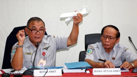 Tatang Kurniadi, left, chief of the National Transportation Safety Committee (NTSC), holds a model plane during a news conference in Jakarta on Thursday. The French first officer of an AirAsia passenger jet that crashed into the sea last month was at the controls at the time of the accident, the NTSC said. INDONESIA-AIRPLANE/