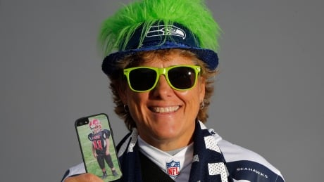 Seattle Seahawks fan Shelley Biggs, 52, poses for a portrait holding a cell phone with a photo of her nine-year-old son Brendan, in Phoenix, Arizona January 31, 2015 before the NFL's Super Bowl XLIX. When asked about the NFL's recent domestic violence controversy Biggs said: "It's about time they do something or they speak up or they say something, because a lot of time these highly paid athletes get away with a lot. They get paid a lot of money and they buy their way out of all kinds of things. Kids idolize them." REUTERS/Lucy Nicholson (UNITED STATES - Tags: SPORT FOOTBALL PORTRAIT) - RTR4NQXE NFL-SUPERBOWL/WOMEN