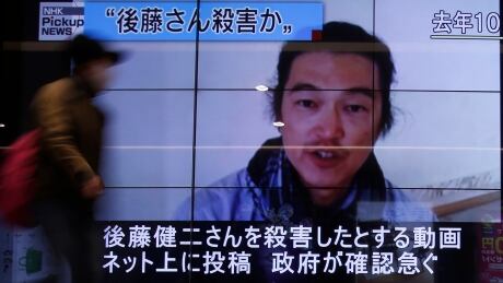 A pedestrian walks past television screens displaying a news program about Japanese journalist Kenji Goto, who was held hostage by Islamic State militants, on a street in Tokyo February 1, 2015. Islamic State militants said they had beheaded a second Japanese hostage, journalist Kenji Goto, prompting Abe to vow to step up humanitarian aid to the group's opponents in the Middle East and help bring his killers to justice. The words on the screen (top L) read, "Goto was murdered ?" MIDEAST-CRISIS/JAPAN-HOSTAGE