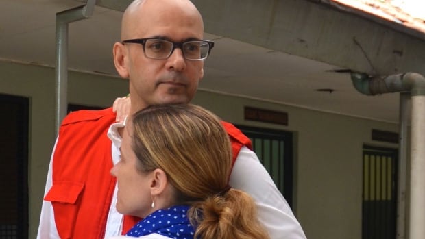 Neil Bantleman hugs his wife, Tracy, ahead of another day in court in Indonesia.