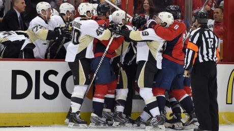 Players from the Pittsburgh Penguins and the Washington Capitals mix it up near the Pittsburgh bench. Penguins Capitals Hockey