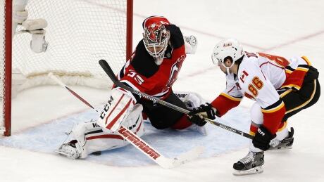 New Jersey Devils goalie Cory Schneider makes a save on the Flames' Josh Jooris attacks during the third period of the game, Wednesday in Newark, N.J. Schneider's efforts wouldn't be enough as Calgary went on to win 3-1. Cory Schneider