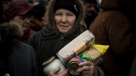 A woman holds humanitarian aid distributed in Popasna, eastern Ukraine, on Saturday. The recent pullback of some weapons from the line separating government and rebel forces in Ukraine seems to have boosted the prospects for peace, though both sides say they're prepared to fight again. Ukraine relief