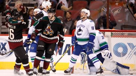 Coyotes' Tobias Rieder celebrates his goal against Canucks' Eddie Lack with teammate Mark Arcobello as Canucks' Ryan Stanton (18) skates away during the first period of the game Thursday in Glendale, Ariz. Canucks Coyotes Hockey