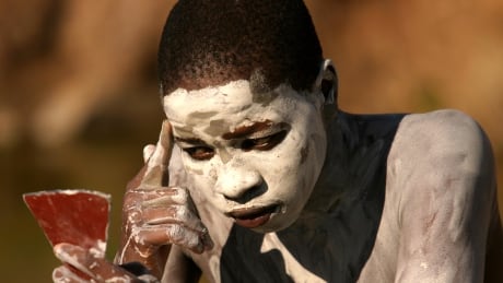 An initiate applies ikota (white lime stone) in the Eastern Cape, South Africa July 20, 2006. Every year thousands of youths leave their parents to spend weeks in the care of traditional leaders at an initiation school where they are circumcised, a rite of passage commonly referred to as Ukwaluka or "going to the mountain". Picture taken July 20, 2006. REUTERS/Siphiwe Sibeko (SOUTH AFRICA) - RTR1FXAZ SAFRICA XHOSA INITIATION