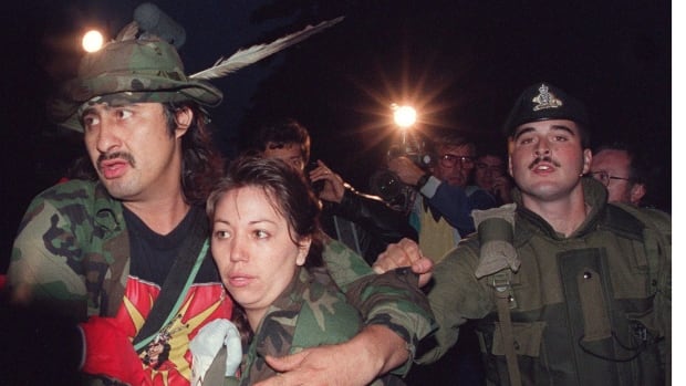 Mohawk Warrior known as Noreiga clutches an unidentified woman as he is taken into custody Sept. 26, 1990 by Canadian soldiers after 78 days defending their land.