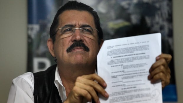 Honduras' ousted President Manuel Zelaya holds up a document during a news conference inside the Brazilian embassy in Tegucigalpa November 4, 2009. Zelaya called on Washington to state clearly whether it supported his return to power or the de facto government that ousted him.